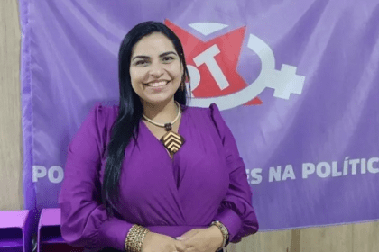 Foto mostra Anne Moura com bandeira do PT ao fundo