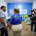 Imagem colorida mostra governador Wilson Lima conversando com a secretária de saúde Nayara Maksoud no espaço de atendimento por telesaúde em Nhamundá
