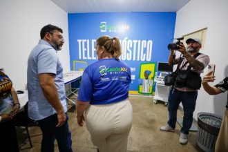 Imagem colorida mostra governador Wilson Lima conversando com a secretária de saúde Nayara Maksoud no espaço de atendimento por telesaúde em Nhamundá