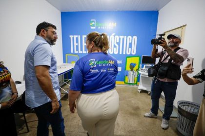 Imagem colorida mostra governador Wilson Lima conversando com a secretária de saúde Nayara Maksoud no espaço de atendimento por telesaúde em Nhamundá