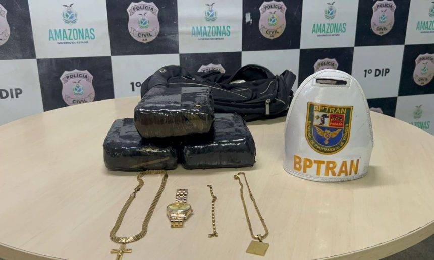 Apreensão de drogas, maconha, em pacotes, além de joias e um boné do BPTran, em cima de uma mesa com o logotipo da Polícia Civil do Amazonas.