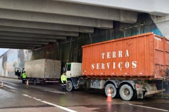 Caminhão com a inscrição 'Terra Serviços' parado embaixo de um viaduto durante fiscalização de carga pesada na avenida Governador José Lindoso.