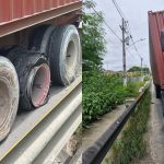 Caminhão com pneus estourados parado na via pública, com um dos pneus completamente desfeito.