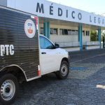Caminhonete branca com a inscrição 'IML-DPTC' estacionada em frente ao prédio do Médico Legal, em Manaus.