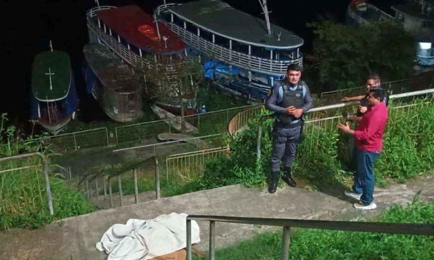 Cena de crime: corpo coberto por um lençol branco em uma escada, policiais e curiosos observam.