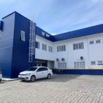 Fachada de um prédio com a inscrição '19ª DP' em destaque, indicando uma delegacia de polícia.