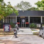 Fachada de uma delegacia de polícia com a placa "DEAAI" e uma placa menor com o texto "Delegacia Especializada em Apuração de Atos Infracionais".