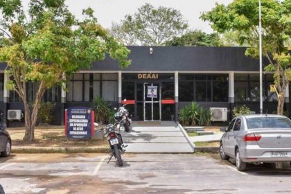 Fachada de uma delegacia de polícia com a placa "DEAAI" e uma placa menor com o texto "Delegacia Especializada em Apuração de Atos Infracionais".