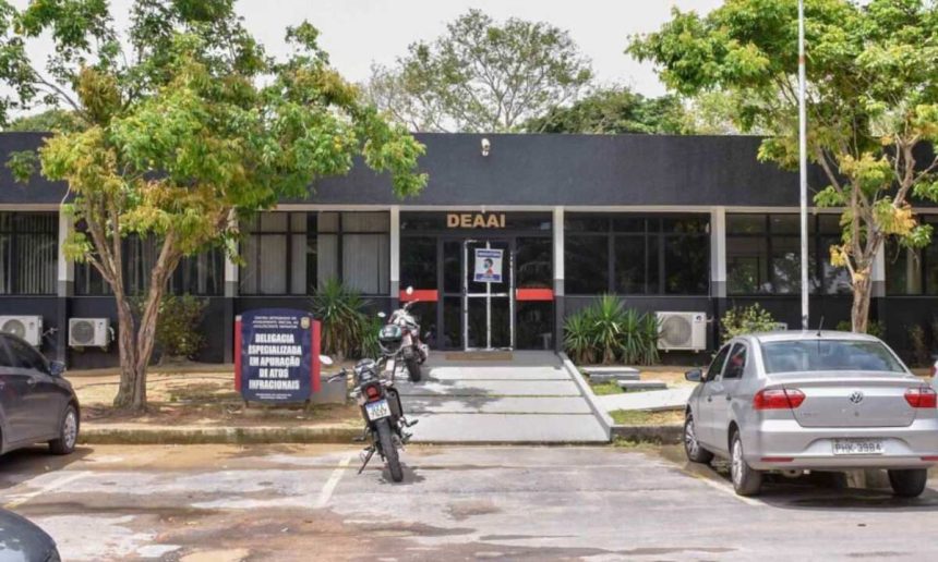 Fachada de uma delegacia de polícia com a placa "DEAAI" e uma placa menor com o texto "Delegacia Especializada em Apuração de Atos Infracionais".