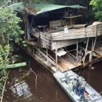 Operação Ágata: Uma embarcação militar próxima a uma estrutura de madeira em um rio, possivelmente em uma área de mata densa.