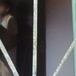 Pessoa em ambiente interno, possivelmente em situação de violência doméstica