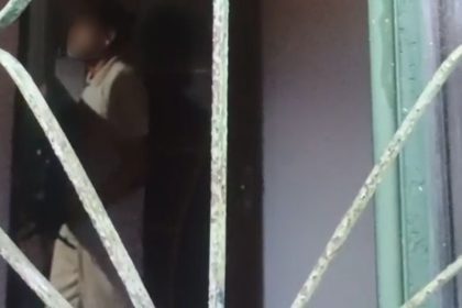 Pessoa em ambiente interno, possivelmente em situação de violência doméstica