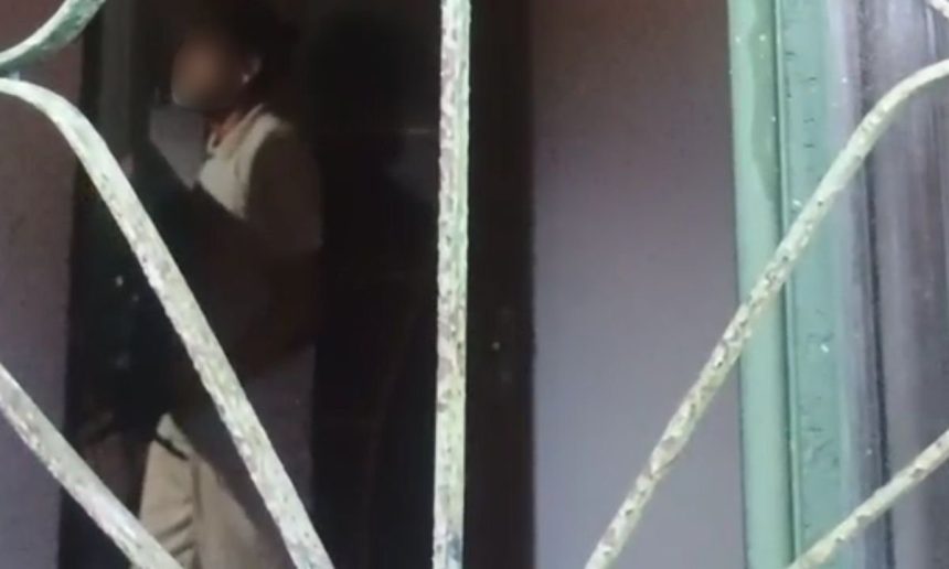 Pessoa em ambiente interno, possivelmente em situação de violência doméstica