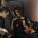 Policiais civis em uma operação, uma policial feminina em destaque, usando uniforme e distintivo.