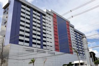 Prédio da Faculdade Metropolitana de Manaus (Fametro), com fachada moderna em tons de branco, azul e vermelho, e muitas janelas.