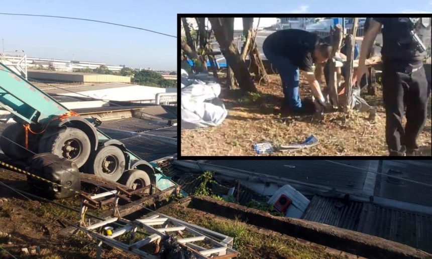 Um caminhão tombado em um acidente com um homem ao fundo no local do acidente