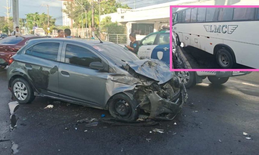 Um carro de passeio cinza com a frente amassada após um acidente com um micro-ônibus branco, que aparece parcialmente na imagem.