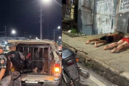 Um casal preso em uma viatura da polícia, ambos com as mãos algemadas e sendo escoltados por policiais militares.