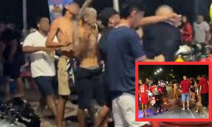 Um grupo de pessoas em uma rua à noite, algumas delas usando camisetas vermelhas. No fundo, um policial de moto. A imagem pode ser relacionada a um incidente de violência.