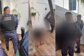 Um homem deitado no chão com policiais ao redor, em uma casa. Há sangue no chão, sugerindo uma situação violenta.