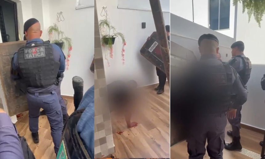 Um homem deitado no chão com policiais ao redor, em uma casa. Há sangue no chão, sugerindo uma situação violenta.