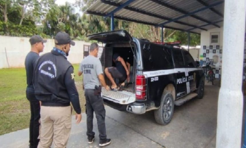 Um homem detido pela polícia, sendo levado para a viatura.