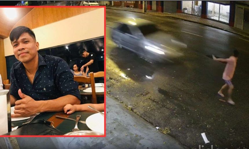Um homem sorri e dá um joinha sentado em uma mesa de restaurante. No fundo, uma outra pessoa aparece em outro ambiente, sendo atropelado por um carro.
