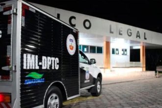 Um veículo preto e branco da polícia, possivelmente uma van, estacionado em frente a um prédio com a placa "Colegial" em destaque.
