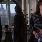 Uma cena do filme 'A Insustentável Leveza do Ser', com um homem refletido em um espelho e uma mulher em primeiro plano.