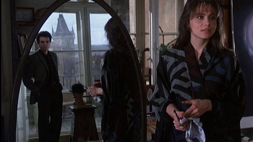 Uma cena do filme 'A Insustentável Leveza do Ser', com um homem refletido em um espelho e uma mulher em primeiro plano.