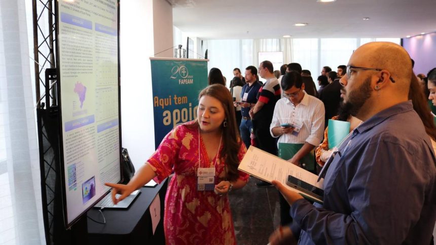 Uma mulher aponta para uma apresentação sobre oncologia em um congresso científico, enquanto um homem a escuta e segura um tablet.