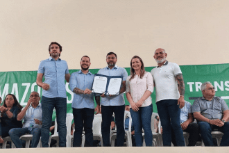 Imagem mostra governador Wilson Lima assinando termo com demais autoridades