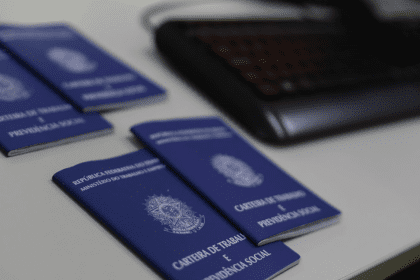 Imagem colorida mostra carteiras de trabalho sobre uma mesa