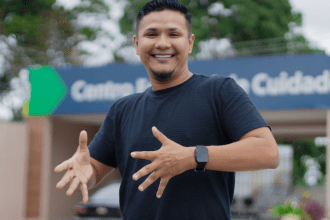 Imagem colorida mostra Homem em frente a secretaria do Governo do Amazonas se expressando em língua sinais