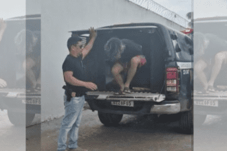 Imagem colorida mostra suspeito de estupro virtual chegando na delegacia se Santo Antônio do Içá