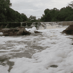 Imagem colorida mostra foto do Igarapé do Tarumã em 2016 coberto de espuma