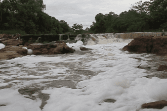 Imagem colorida mostra foto do Igarapé do Tarumã em 2016 coberto de espuma