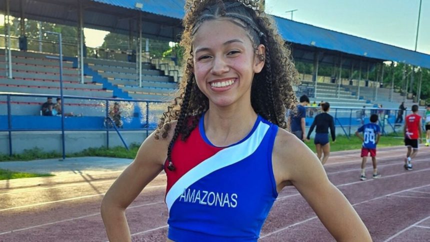 Samara Macena, atleta amazonense, celebra vitória no atletismo, com braços erguidos e sorriso radiante.