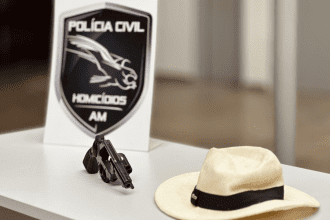 Imagem colorida mostra arma e chapéu do suspeito do crime encontrados pela Polícia