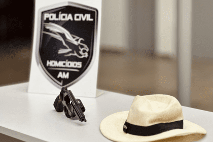 Imagem colorida mostra arma e chapéu do suspeito do crime encontrados pela Polícia