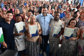 Imagem colorida mostra Wilson Lima entregando títulos definitivos