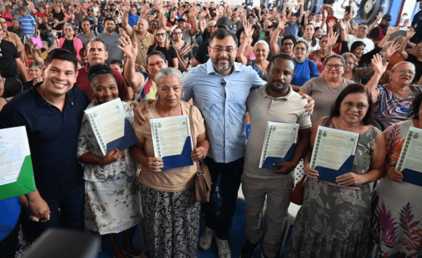 Imagem colorida mostra Wilson Lima entregando títulos definitivos
