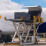 Imagem colorida mostra cargas sendo transportadas no Aeroporto de Manaus