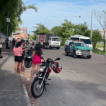 Imagem colorida mostra carro da polícia militar próximo a corpo estirado no chão na Manaus 2000