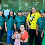 Imagem colorida mostra comunitários da Vila de Paricatuba em frente a banner do Projeto Viva Paricatuba