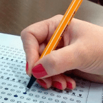 Imagem colorida mostra mão realizando marcação de gabarito do Concurso Nacional Unificado