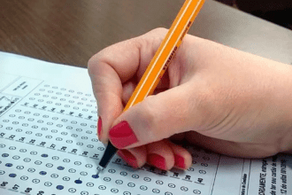 Imagem colorida mostra mão realizando marcação de gabarito do Concurso Nacional Unificado