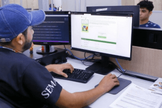 Imagem colorida mostra Pessoa em frente a um computador mostrando aceso ao site do Bolsa Universidade Manaus