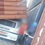 Imagem colorida mostra contêineres caídos em caminhão e motorista saindo