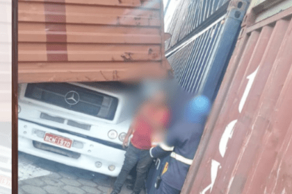 Imagem colorida mostra contêineres caídos em caminhão e motorista saindo